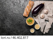 Bowl with tasty baba ghanoush and ingredients on dark background. Стоковое фото, фотограф Pixel_shot / Фотобанк Лори