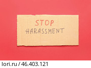 Cardboard with text STOP HARASSMENT on color background. Стоковое фото, фотограф Pixel_shot / Фотобанк Лори
