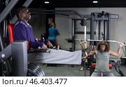 African man doing leg raises on captains chair in gym. Стоковое фото, фотограф Яков Филимонов / Фотобанк Лори