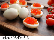 Tasty deviled eggs on wooden board, closeup. Стоковое фото, фотограф Pixel_shot / Фотобанк Лори