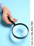 Female hand with magnifier on blue background. Стоковое фото, фотограф Pixel_shot / Фотобанк Лори