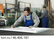 In workshop for production of glass products, man co-worker cuts off excess from workpiece. Стоковое фото, фотограф Яков Филимонов / Фотобанк Лори