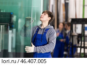 Guy glazer employee in blue overall works in glass processing shop. Стоковое фото, фотограф Яков Филимонов / Фотобанк Лори