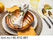 Stylish dinnerware with autumn decor and pumpkin shaped plate on light table. Стоковое фото, фотограф Pixel_shot / Фотобанк Лори