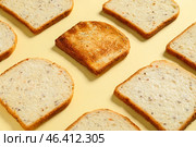 Toasted bread among fresh ones on color background. Concept of uniqueness. Стоковое фото, фотограф Pixel_shot / Фотобанк Лори