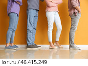 Young people waiting in line near color wall. Стоковое фото, фотограф Pixel_shot / Фотобанк Лори