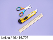 Utility knife with scissors and ruler on violet background. Стоковое фото, фотограф Pixel_shot / Фотобанк Лори