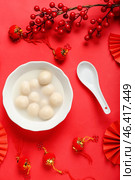 Bowl of tasty tangyuan and Chinese decor on red background. Dongzhi Festival. Стоковое фото, фотограф Pixel_shot / Фотобанк Лори