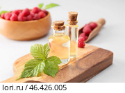 Bottles of raspberry essential oil on light background. Стоковое фото, фотограф Pixel_shot / Фотобанк Лори