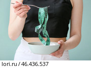 Тощая женщина с измерительной лентой, миской и вилкой на цветном фоне. Понятие анорексии. Стоковое фото, фотограф Pixel_shot / Фотобанк Лори