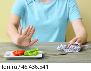 Худенькая женщина отказывается есть овощи за столом. Понятие анорексии. Стоковое фото, фотограф Pixel_shot / Фотобанк Лори