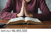 Woman is praying while holding a book open in front of her. Стоковое AI-видео, аниматор Sergey Grishin / Фотобанк Лори