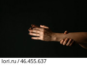 Руки женщины, страдающей синдромом Паркинсона на темном фоне. Стоковое фото, фотограф Pixel_shot / Фотобанк Лори