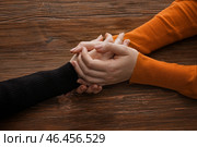 Руки женщины утешают подругу на деревянном фоне. Стоковое фото, фотограф Pixel_shot / Фотобанк Лори