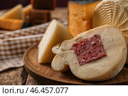 Деревянная тарелка с ассортиментом вкусных сыров на столе. Стоковое фото, фотограф Pixel_shot / Фотобанк Лори