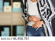 Молодая женщина страдает от боли в животе в домашних условиях. Стоковое фото, фотограф Pixel_shot / Фотобанк Лори