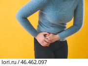 Молодая женщина страдает от боли в животе на цветном фоне. Стоковое фото, фотограф Pixel_shot / Фотобанк Лори