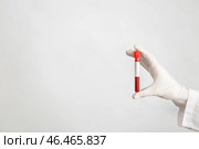 Лаборант держит пробирку с образцом крови на белом фоне. Стоковое фото, фотограф Pixel_shot / Фотобанк Лори