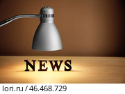 Слово NEWS освещается с помощью лампы на столе. Стоковое фото, фотограф Pixel_shot / Фотобанк Лори