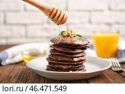 Лить мед на вкусные шоколадные блины на тарелке. Стоковое фото, фотограф Pixel_shot / Фотобанк Лори