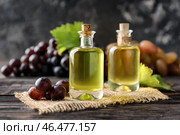 Бутылки с маслом из виноградных косточек на деревянном столе. Стоковое фото, фотограф Pixel_shot / Фотобанк Лори