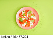 Тарелка вкусного салата капрезе на зеленом фоне. Стоковое фото, фотограф Pixel_shot / Фотобанк Лори