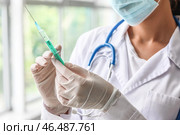 Женщина-врач с медицинской маской и шприцем в клинике крупным планом. Стоковое фото, фотограф Pixel_shot / Фотобанк Лори