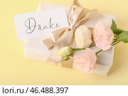Подарочная коробка, открытка с текстом DANKE и цветами эустомы на цветном фоне, крупным планом. Стоковое фото, фотограф Pixel_shot / Фотобанк Лори