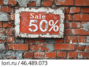 На кирпичной стене висит объявление о 50-процентной распродаже. Стоковое AI-изображение, AI-художник Ярославский Максим / Фотобанк Лори