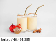 Стаканы вкусного коктейля из гоголя-моголь, елочный шар, печенье и специи на белом фоне. Стоковое фото, фотограф Pixel_shot / Фотобанк Лори