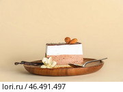 Деревянная тарелка с кусочком птичьего молока, миндальными орехами, ванилью и ложкой на бежевом фоне. Стоковое фото, фотограф Pixel_shot / Фотобанк Лори