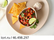 Чаша вкусной сальсы Пико де Галло и начос на столе. Стоковое фото, фотограф Pixel_shot / Фотобанк Лори