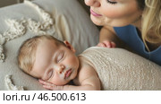 Mother looking at her newborn baby sleeping peacefully. Стоковое AI-видео, аниматор Юрий Поздников / Фотобанк Лори