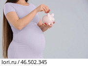 Молодая беременная женщина класть монету в копилку на светлом фоне, крупным планом. Концепция материнского пособия. Стоковое фото, фотограф Pixel_shot / Фотобанк Лори
