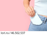 Молодая женщина с гигиенической прокладкой в кармане на розовом фоне, крупным планом. Стоковое фото, фотограф Pixel_shot / Фотобанк Лори