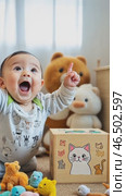 Adorable baby pointing upward surrounded by plush toys. Стоковое AI-видео, аниматор Юрий Поздников / Фотобанк Лори