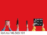 Множество рук с ведром попкорна, кинематографическим хлопушкой и пивом на красном фоне. Стоковое фото, фотограф Pixel_shot / Фотобанк Лори