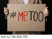 Женщина держит картон с хэштегом METOO на темном фоне, крупный план. Стоковое фото, фотограф Pixel_shot / Фотобанк Лори