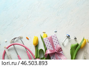 Стетоскоп с жёлтыми тюльпанами, подарочная коробка и ампулы для Международного дня медсестры на светло-голубом фоне. Стоковое фото, фотограф Pixel_shot / Фотобанк Лори