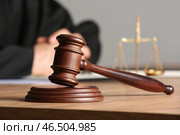 Судейский молоток на столе напротив мужчины-адвоката в офисе. Стоковое фото, фотограф Pixel_shot / Фотобанк Лори