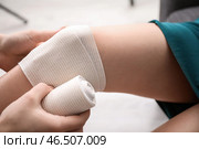 Женщина накладывает повязку на женское колено, крупным планом. Стоковое фото, фотограф Pixel_shot / Фотобанк Лори