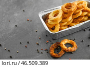 Коробка на вынос с вкусными кольцами лука на сером столе. Стоковое фото, фотограф Pixel_shot / Фотобанк Лори
