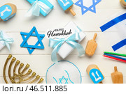 Композиция к Хануке с подарочной коробкой, флагом Израиля, крутильцами и меньорой на белом деревянном фоне. Стоковое фото, фотограф Pixel_shot / Фотобанк Лори