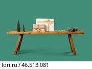 Деревянная скамейка с подарками на Рождество и игрушечными елочками на зеленом фоне. Стоковое фото, фотограф Pixel_shot / Фотобанк Лори