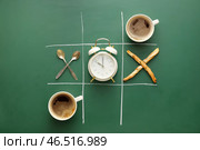 Игра крестики-нолики. Креативная композиция с будильником и чашками кофе. Стоковое фото, фотограф Pixel_shot / Фотобанк Лори