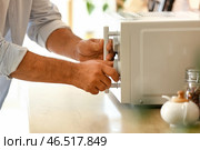 Зрелый мужчина разогревает еду в микроволновой печи, крупным планом. Стоковое фото, фотограф Pixel_shot / Фотобанк Лори