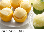 Тарелки с вкусным мороженым в кожуре цитрусовых на светлом фоне. Стоковое фото, фотограф Pixel_shot / Фотобанк Лори