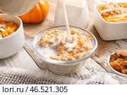 Наливание молока в миску с вкусной овсянкой на белом деревянном фоне. Стоковое фото, фотограф Pixel_shot / Фотобанк Лори