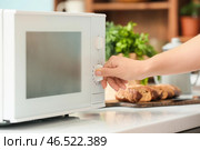 Домохозяйка регулирует современную микроволновую печь на кухне, крупным планом. Стоковое фото, фотограф Pixel_shot / Фотобанк Лори