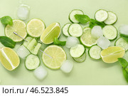 Свежая лаймовый с огурцом, мятой и кубиками льда на зеленом фоне. Ингредиенты для мохито. Стоковое фото, фотограф Pixel_shot / Фотобанк Лори